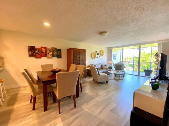 a living room with furniture and a large window with wooden floor