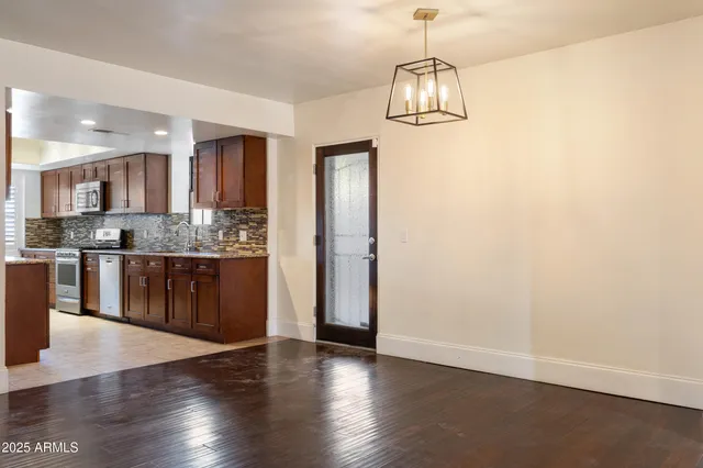 a kitchen with stainless steel appliances granite countertop a refrigerator and a stove top oven