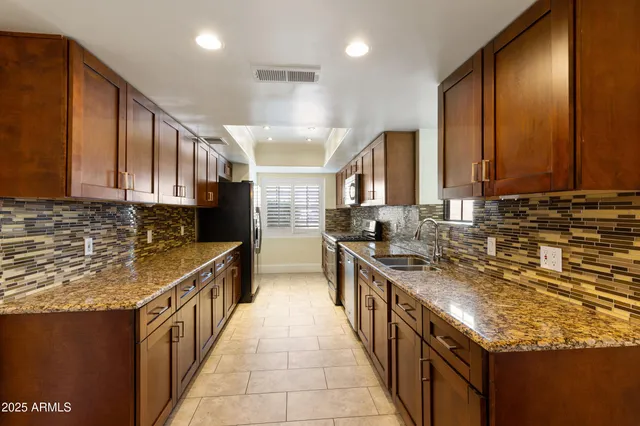 a kitchen with stainless steel appliances granite countertop a sink stove and cabinets