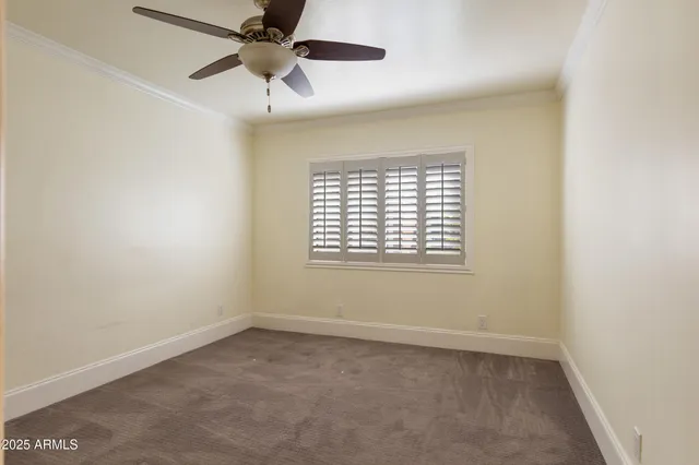 an empty room with a window and a fan