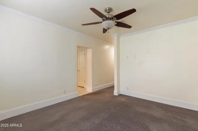 an empty room with a ceiling fan and a window