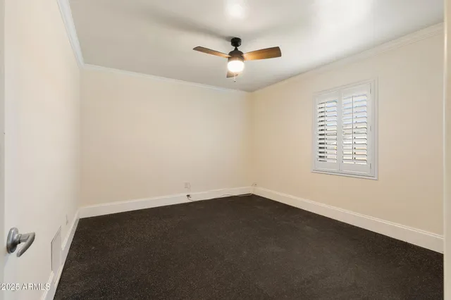 an empty room with a ceiling fan and a window