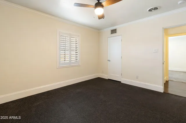 an empty room with a window and a ceiling fan