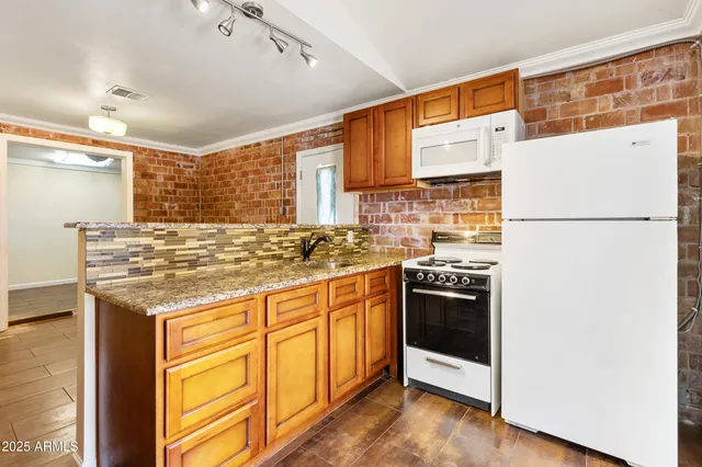 a view of a hallway with wooden floor and a kitchen