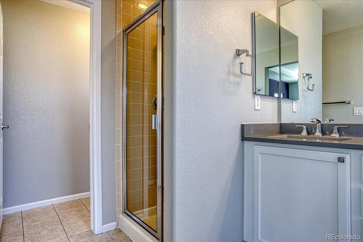 4005 Blue Pine Circle Highlands Ranch, CO 80126 - Photo 19 of 27 a bathroom with a granite countertop sink and a mirror