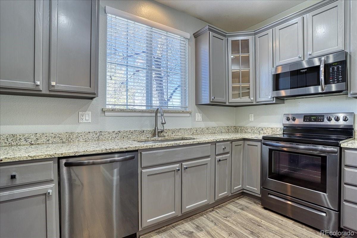 4005 Blue Pine Circle Highlands Ranch, CO 80126 - Photo 8 of 27 a kitchen with stainless steel appliances granite countertop a stove a sink and a microwave