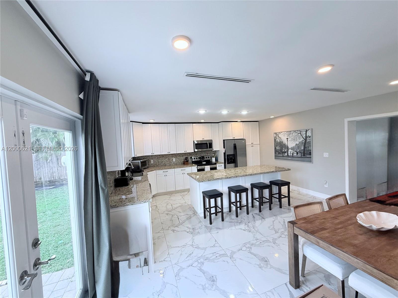 11020 Southwest 42nd Terrace Miami, FL 33165 - Photo 4 of 22 a large kitchen with a table and chairs