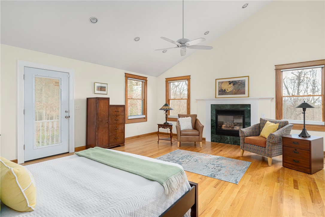 267 Widow Sweets Road Exeter, RI 02822 - Photo 16 of 46 First floor second bedroom with a cathedral ceiling, gas fireplace and access to the front porch. There is also a half bath in this room.