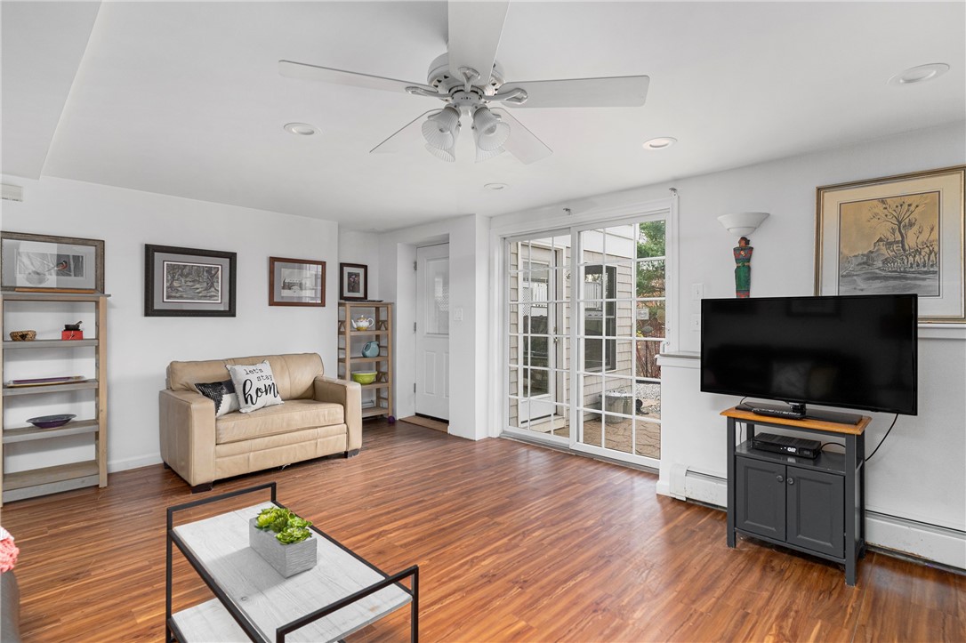 267 Widow Sweets Road Exeter, RI 02822 - Photo 21 of 46 Main house lower level living room with glass sliders to the back patio and the door to the left which leads to the 4 season sun room.