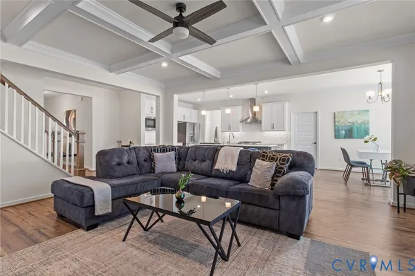 a living room with furniture wooden floor and a chandelier