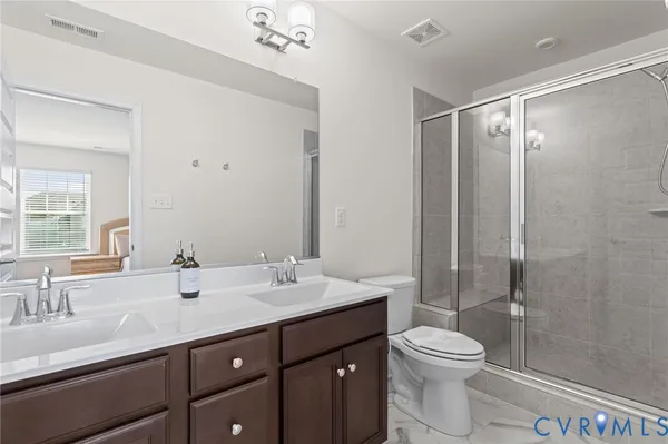 a bathroom with a double vanity sink toilet and shower