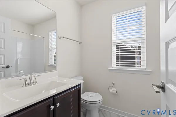 a bathroom with a granite countertop sink toilet and a mirror