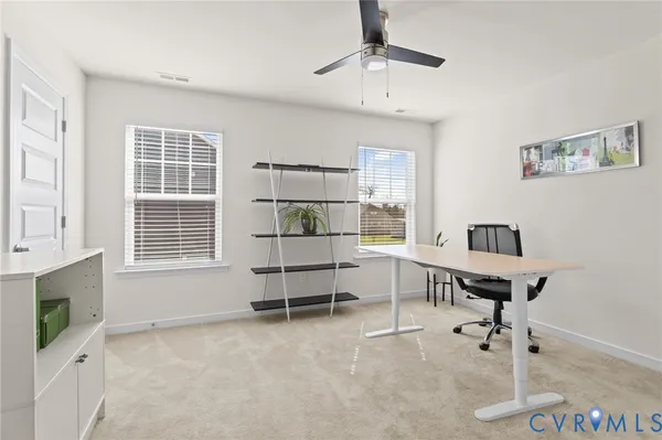 a view of a workspace with furniture and a window