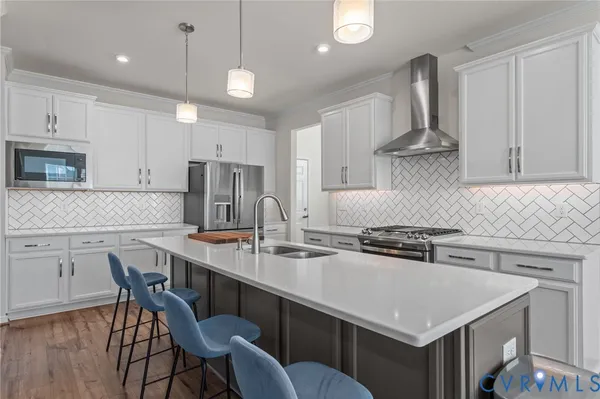 a kitchen with stainless steel appliances a table chairs in it and white cabinets