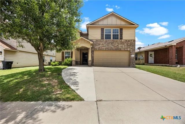 a front view of a house with a yard and garage