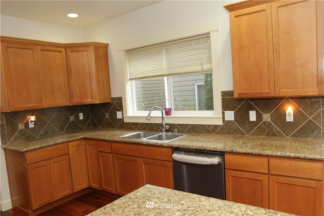 4326 226th Place Southeast Bothell, WA 98021 - Photo 14 of 37 a kitchen with stainless steel appliances granite countertop wooden cabinets a sink and dishwasher