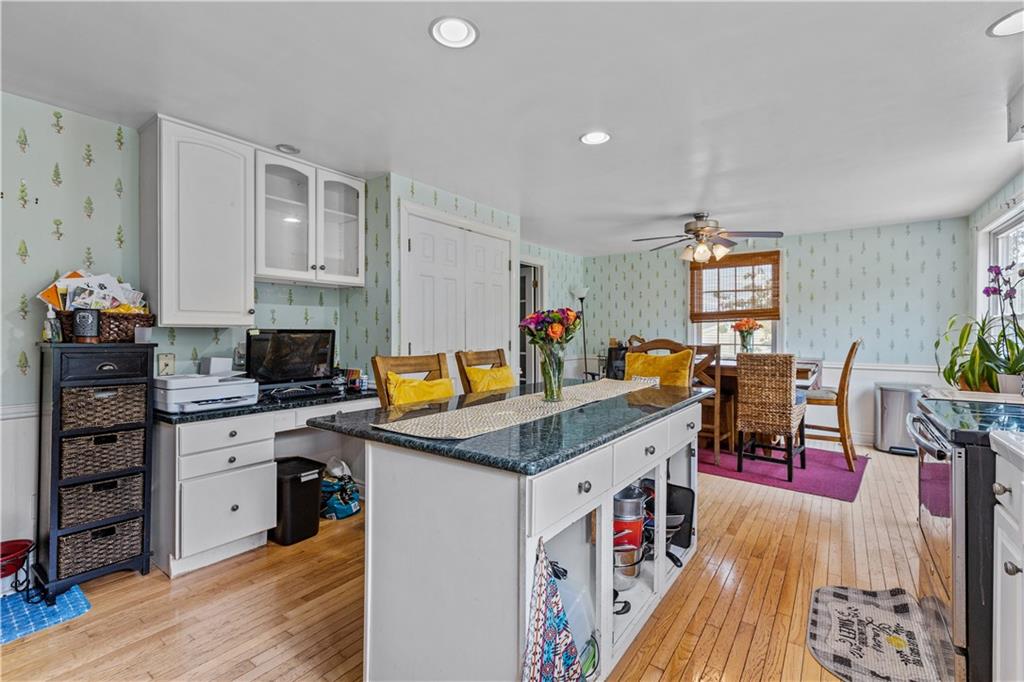 2116 Ramsey Road Monroeville, PA 15146 - Photo 11 of 28 a open kitchen with stainless steel appliances granite countertop a stove top oven a dining table and chairs with wooden floor