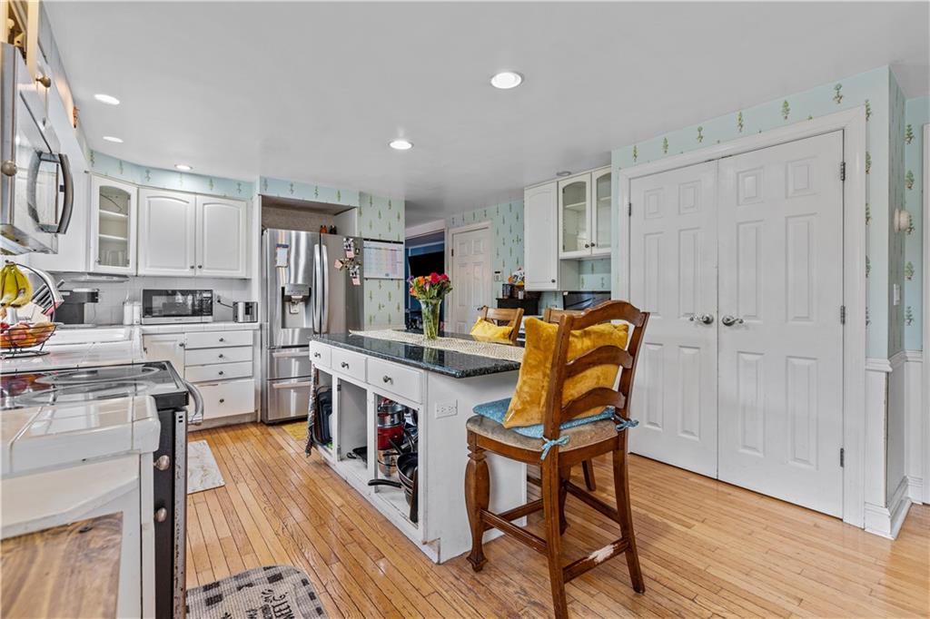 2116 Ramsey Road Monroeville, PA 15146 - Photo 13 of 28 a kitchen with stainless steel appliances granite countertop a stove top oven a sink dishwasher and white cabinets with wooden floor