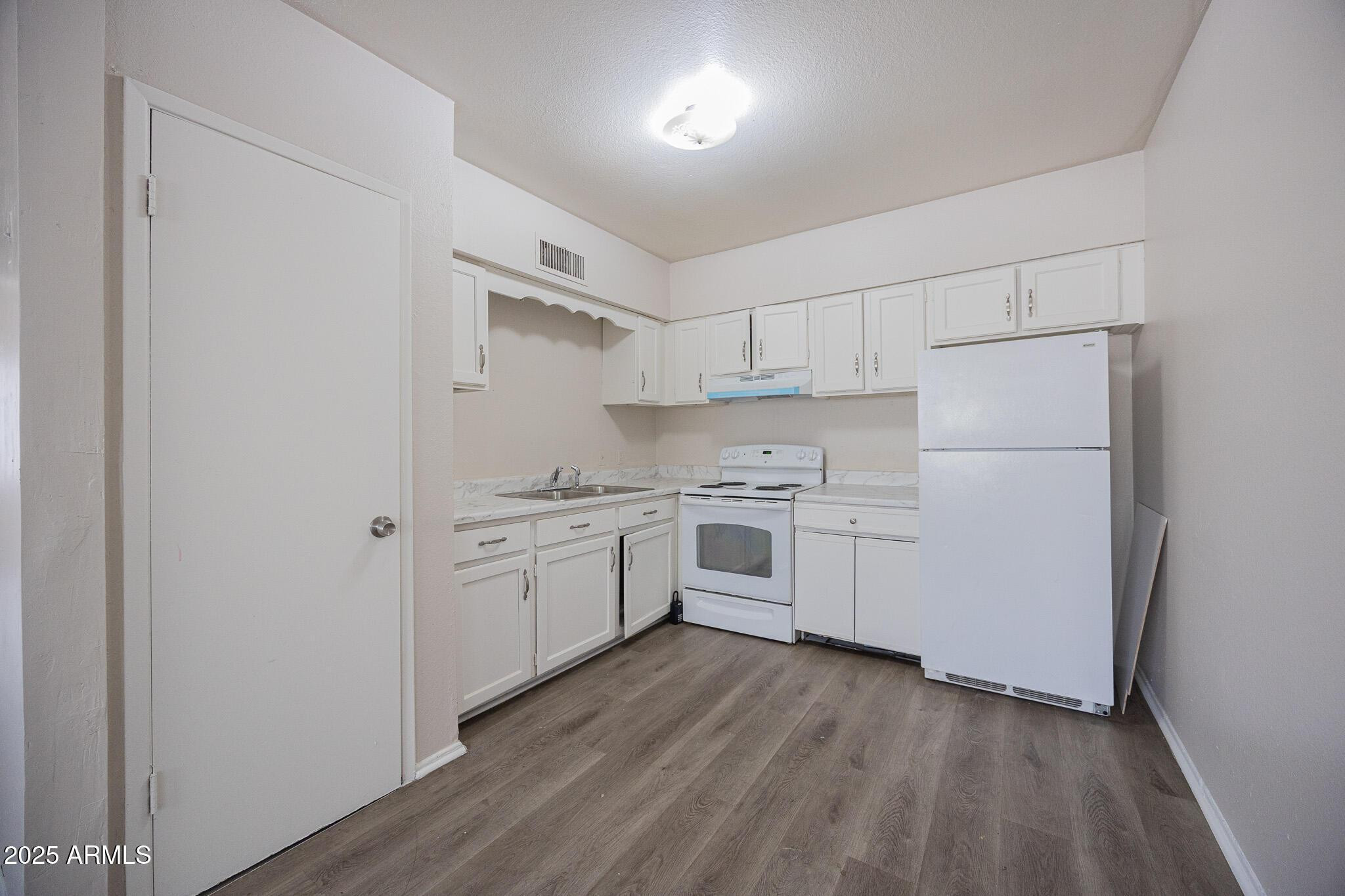 2352 East Broadway Road, Unit A Mesa, AZ 85204 - Photo 3 of 14 a kitchen with white cabinets and white appliances