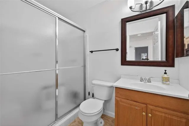 a bathroom with a toilet a sink a mirror and vanity
