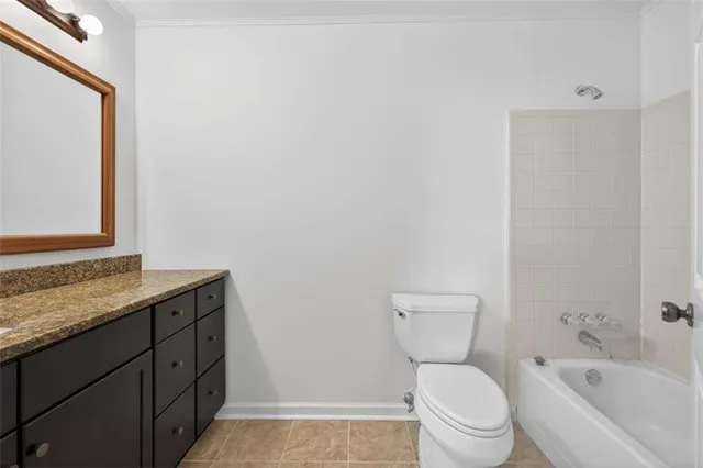 a bathroom with a granite countertop toilet a sink and a bathtub