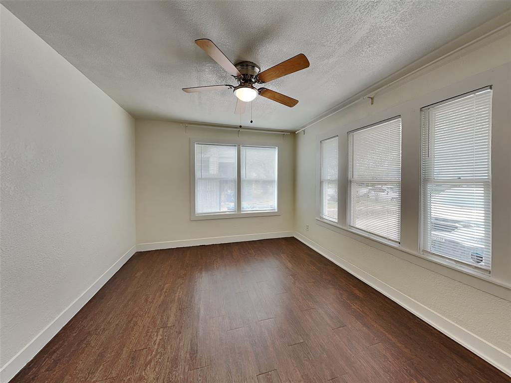 2911 Ryan Avenue Fort Worth, TX 76110 - Photo 13 of 27 a view of an empty room with wooden floor and a window