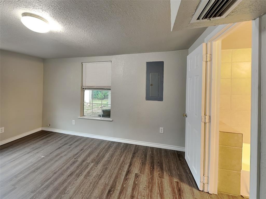 2911 Ryan Avenue Fort Worth, TX 76110 - Photo 20 of 27 an empty room with wooden floor and windows