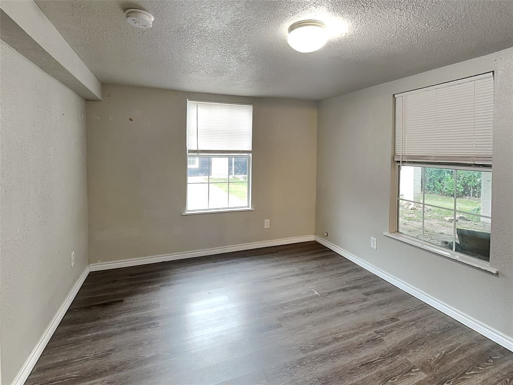 2911 Ryan Avenue Fort Worth, TX 76110 - Photo 21 of 27 an empty room with wooden floor and windows