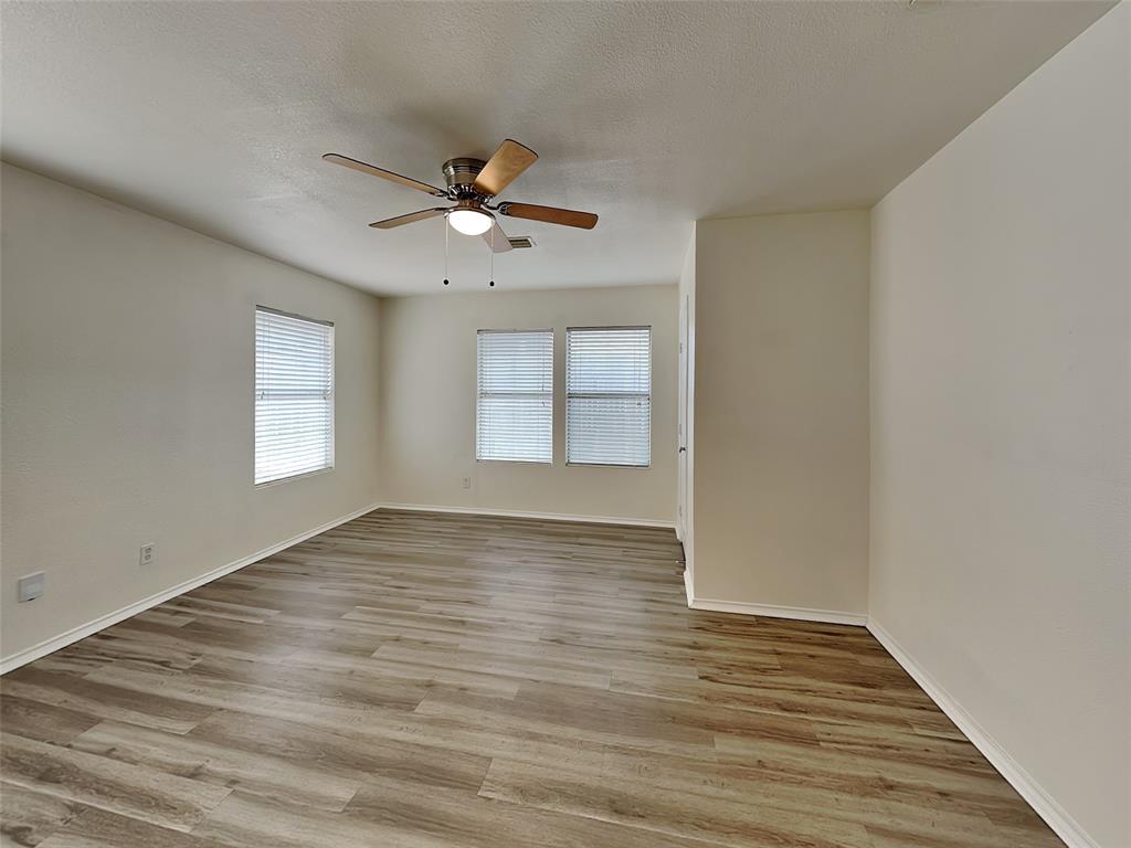 2911 Ryan Avenue Fort Worth, TX 76110 - Photo 10 of 27 a view of empty room with wooden floor and fan