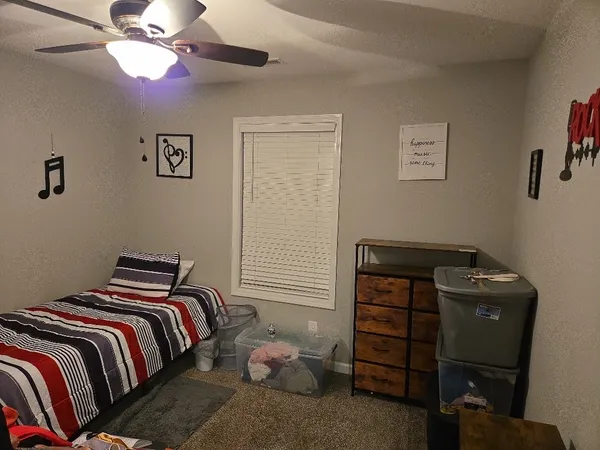 a bedroom with a bed and a ceiling fan