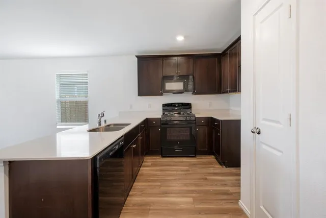 a kitchen with stainless steel appliances kitchen island granite countertop a stove top oven a sink and a microwave