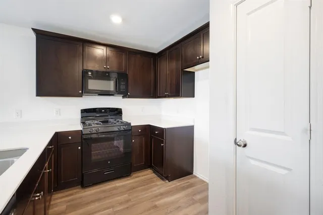 a kitchen with stainless steel appliances granite countertop a refrigerator and a stove top oven