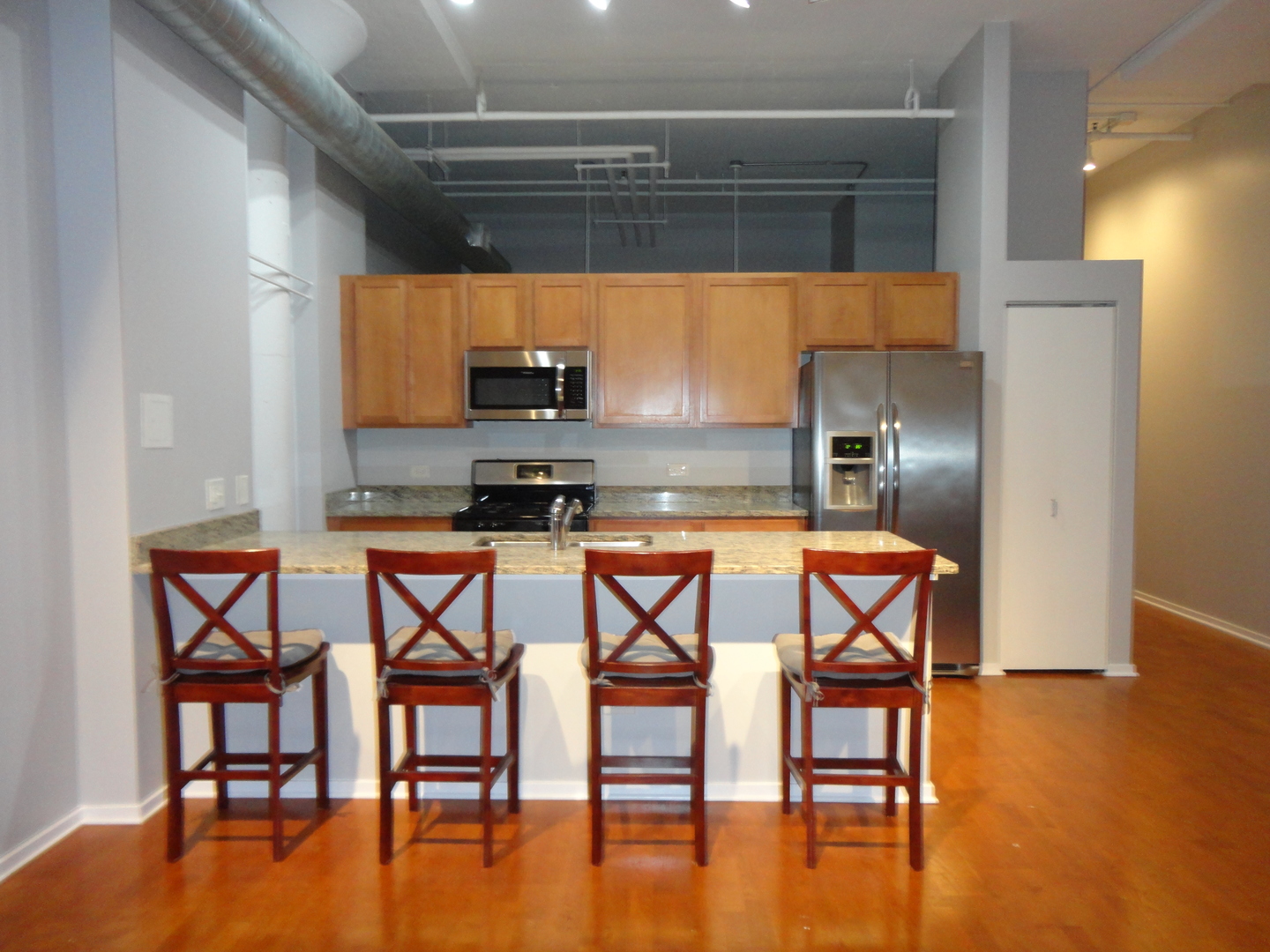 2323 West Pershing Road, Unit 136 Chicago, IL 60609 - Photo 11 of 20 a kitchen with stainless steel appliances a dining table chairs and granite counter tops