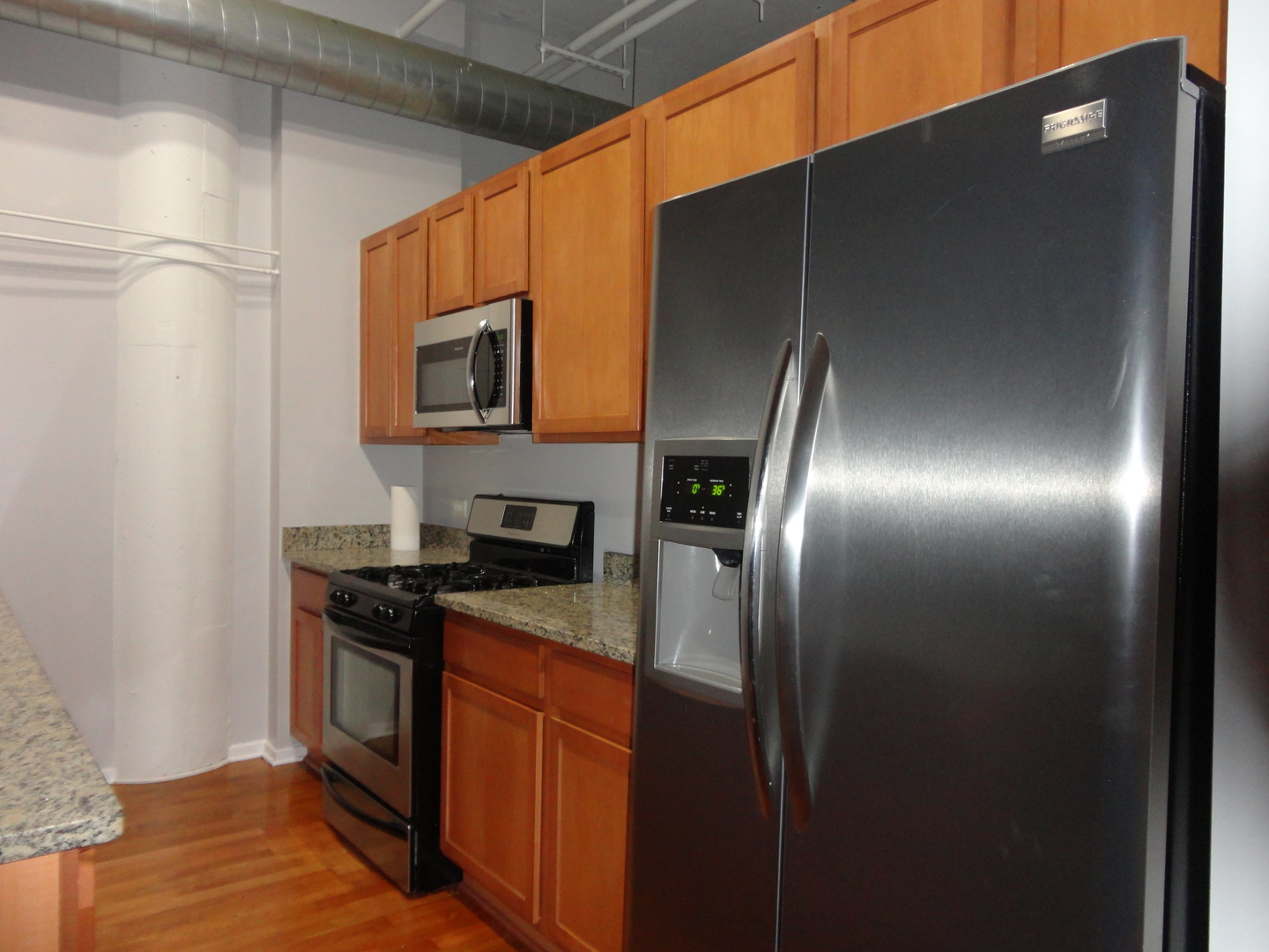 2323 West Pershing Road, Unit 136 Chicago, IL 60609 - Photo 14 of 20 a kitchen with stainless steel appliances granite countertop a stove a sink and a refrigerator
