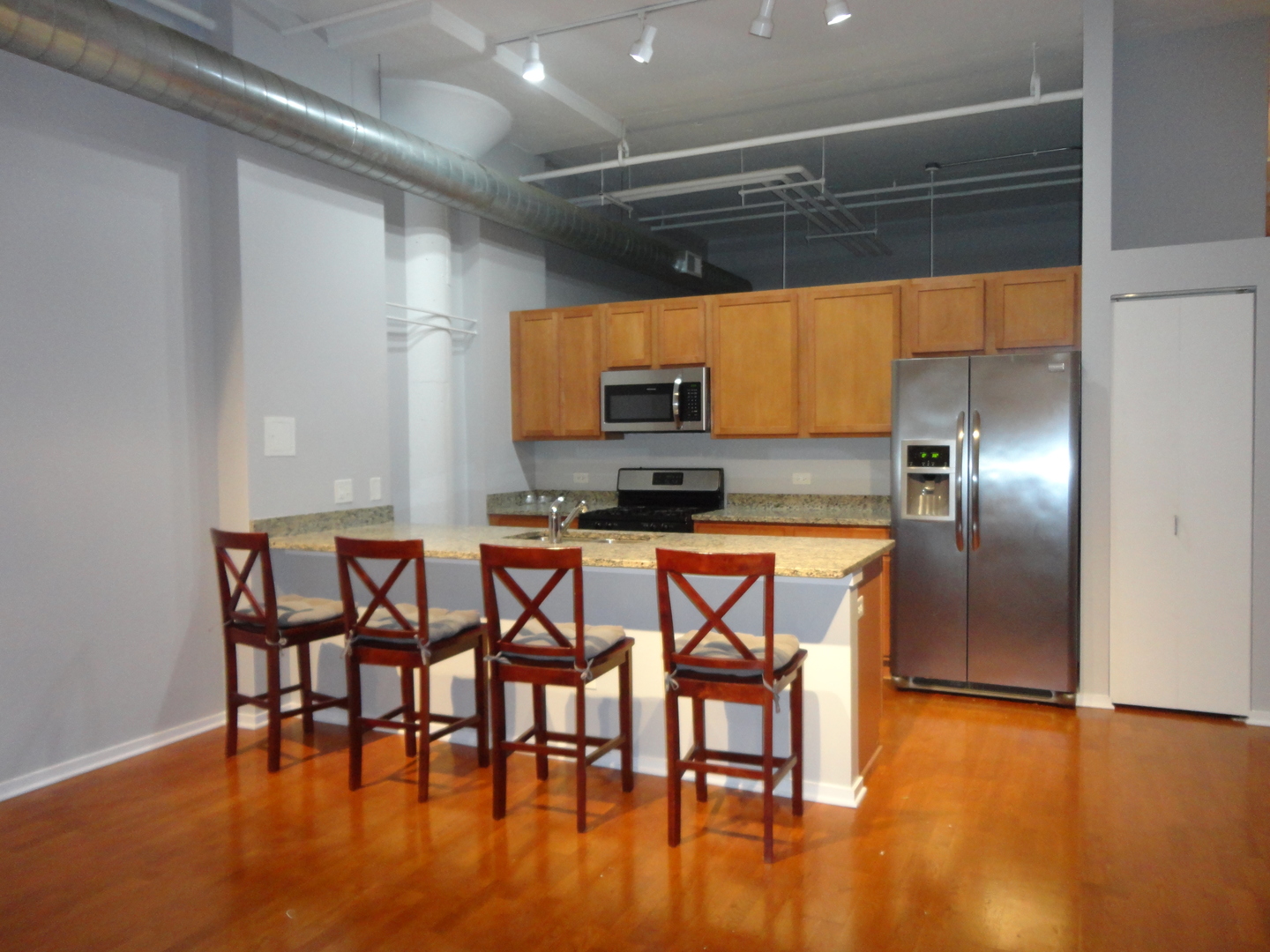 2323 West Pershing Road, Unit 136 Chicago, IL 60609 - Photo 9 of 20 a kitchen with stainless steel appliances a dining table chairs and granite counter tops