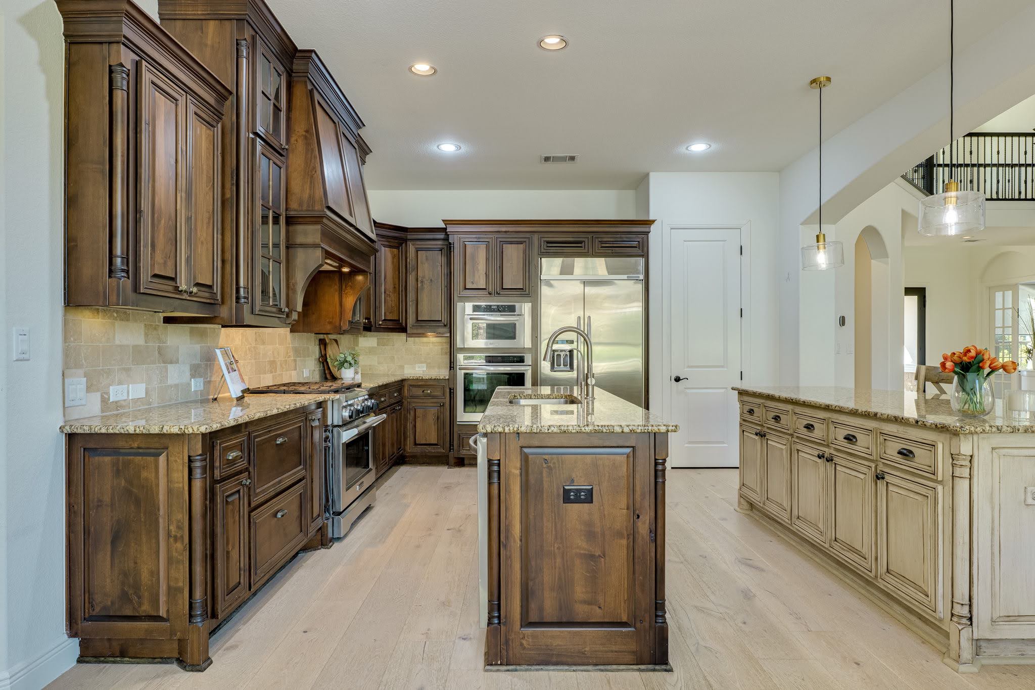11612 Shoreview Overlook Austin, TX 78732 - Photo 15 of 40 Rich wood cabinetry contrasts beautifully with light flooring and dual islands in this spacious design.