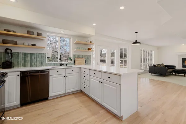 a large kitchen with granite countertop a large counter top a sink stainless steel appliances and cabinets