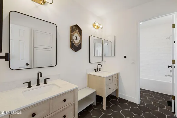 a bathroom with a double vanity sink mirror and bathtub