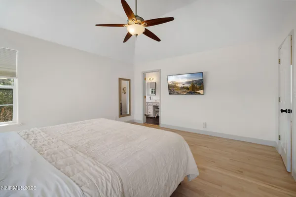a bedroom with a large bed and a ceiling fan
