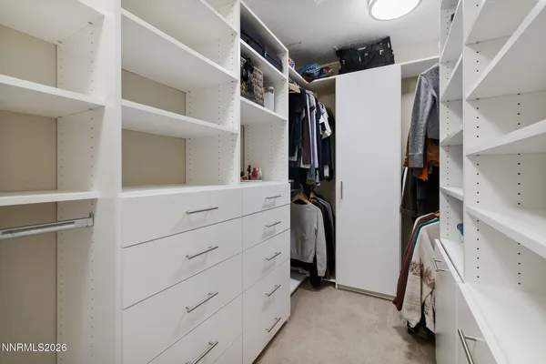 a view of walk in closet with clothes and shoes