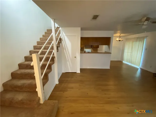a kitchen with a refrigerator a stove and wooden floor