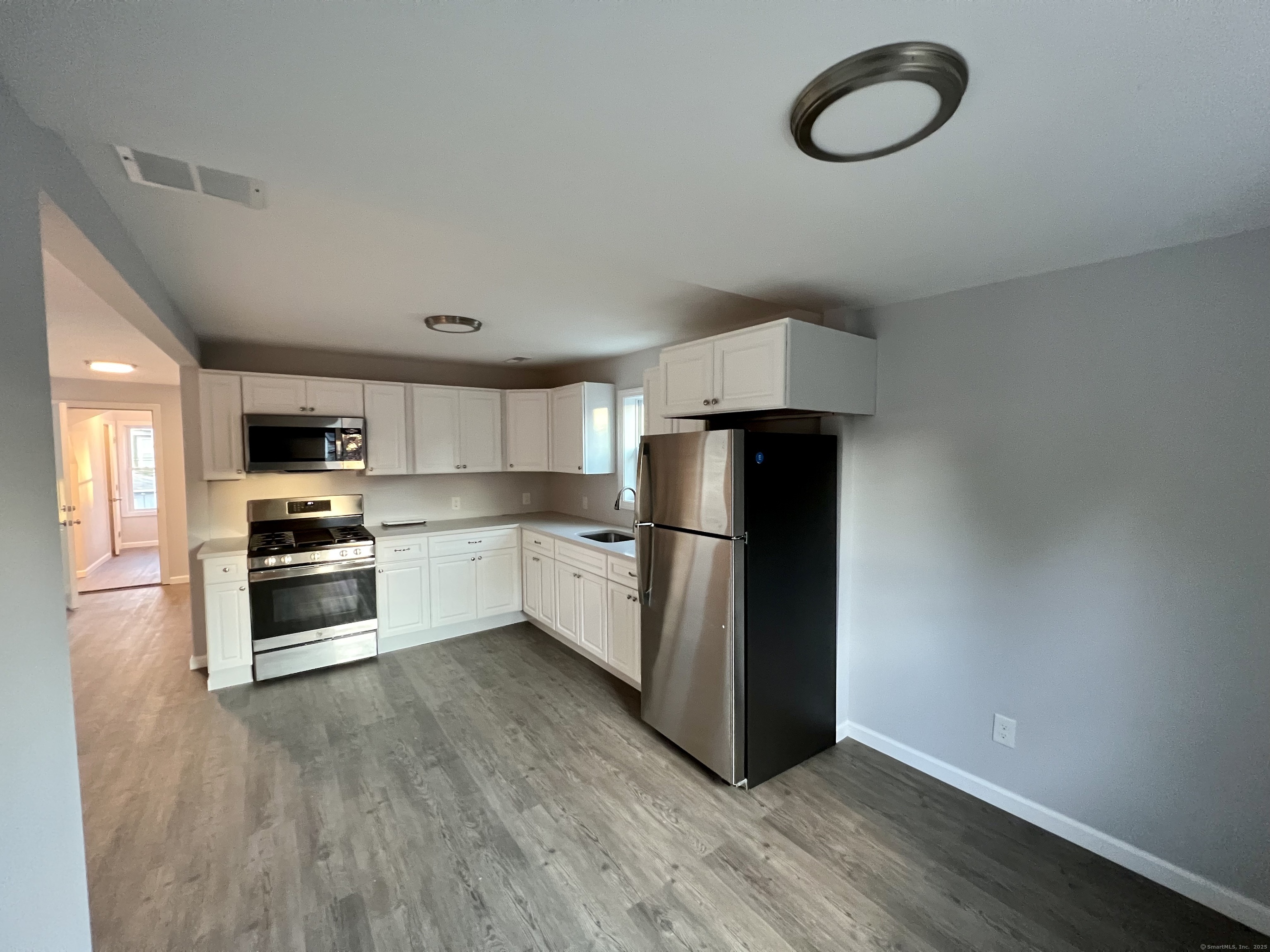 415 Hollister Avenue Bridgeport, CT 06607 - Photo 2 of 14 a kitchen with stainless steel appliances a refrigerator and a stove top oven