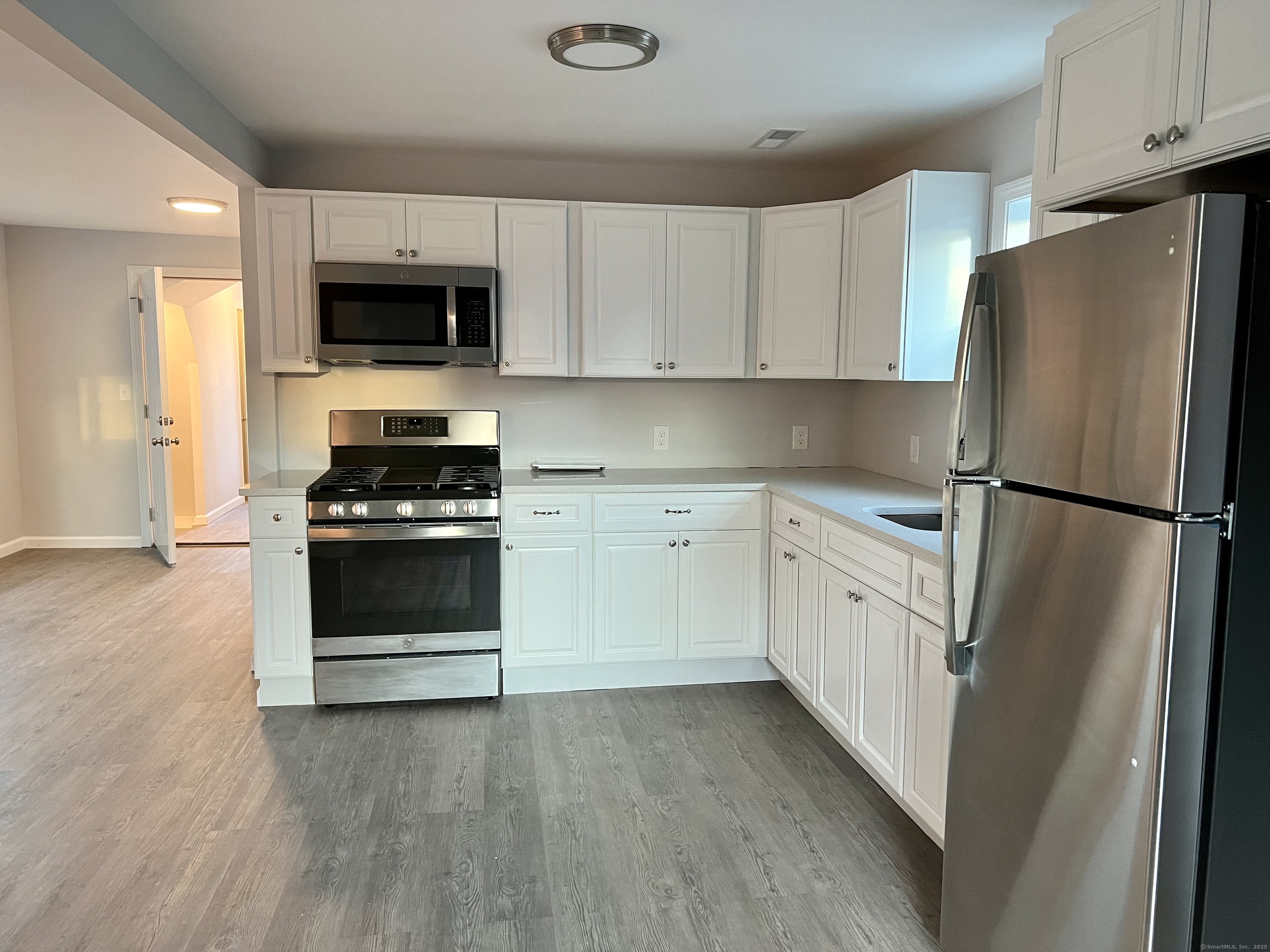 415 Hollister Avenue Bridgeport, CT 06607 - Photo 3 of 14 a kitchen with white cabinets and white appliances