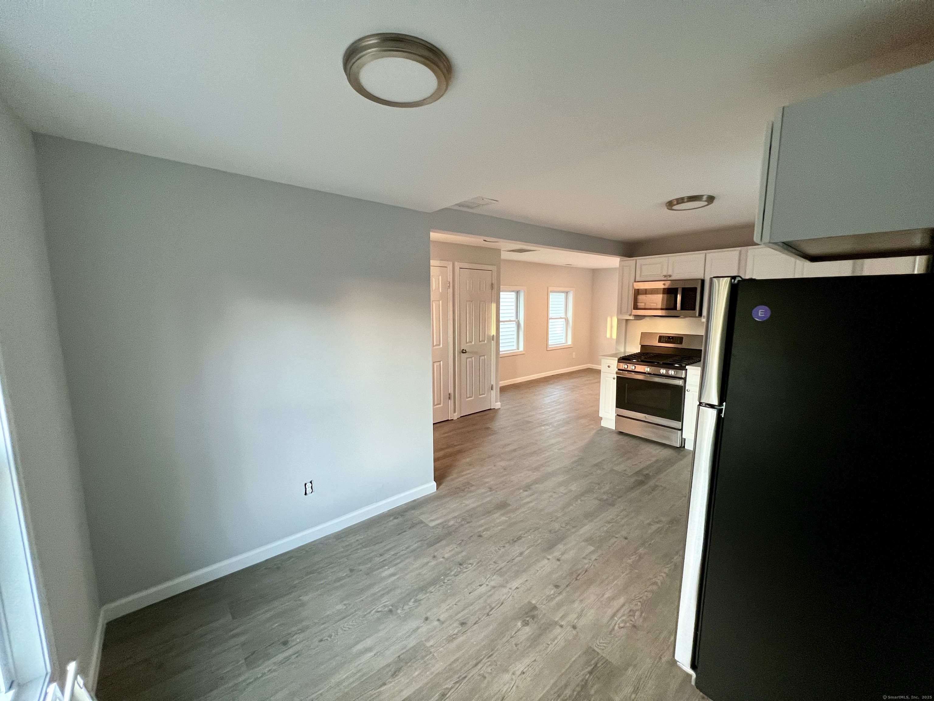415 Hollister Avenue Bridgeport, CT 06607 - Photo 4 of 14 an empty room with wooden floor and a cabinet