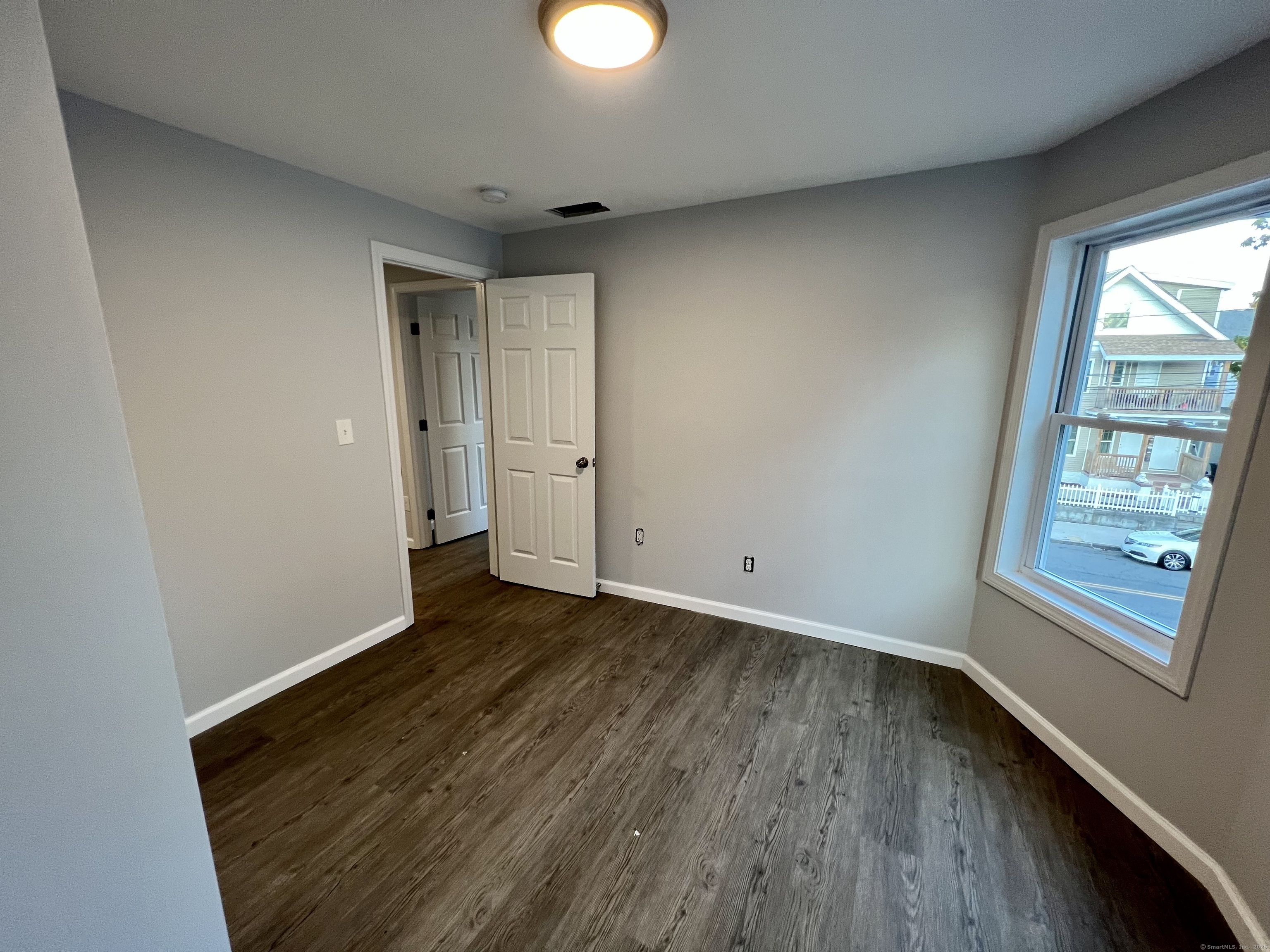 415 Hollister Avenue Bridgeport, CT 06607 - Photo 6 of 14 wooden floor in an empty room with a window