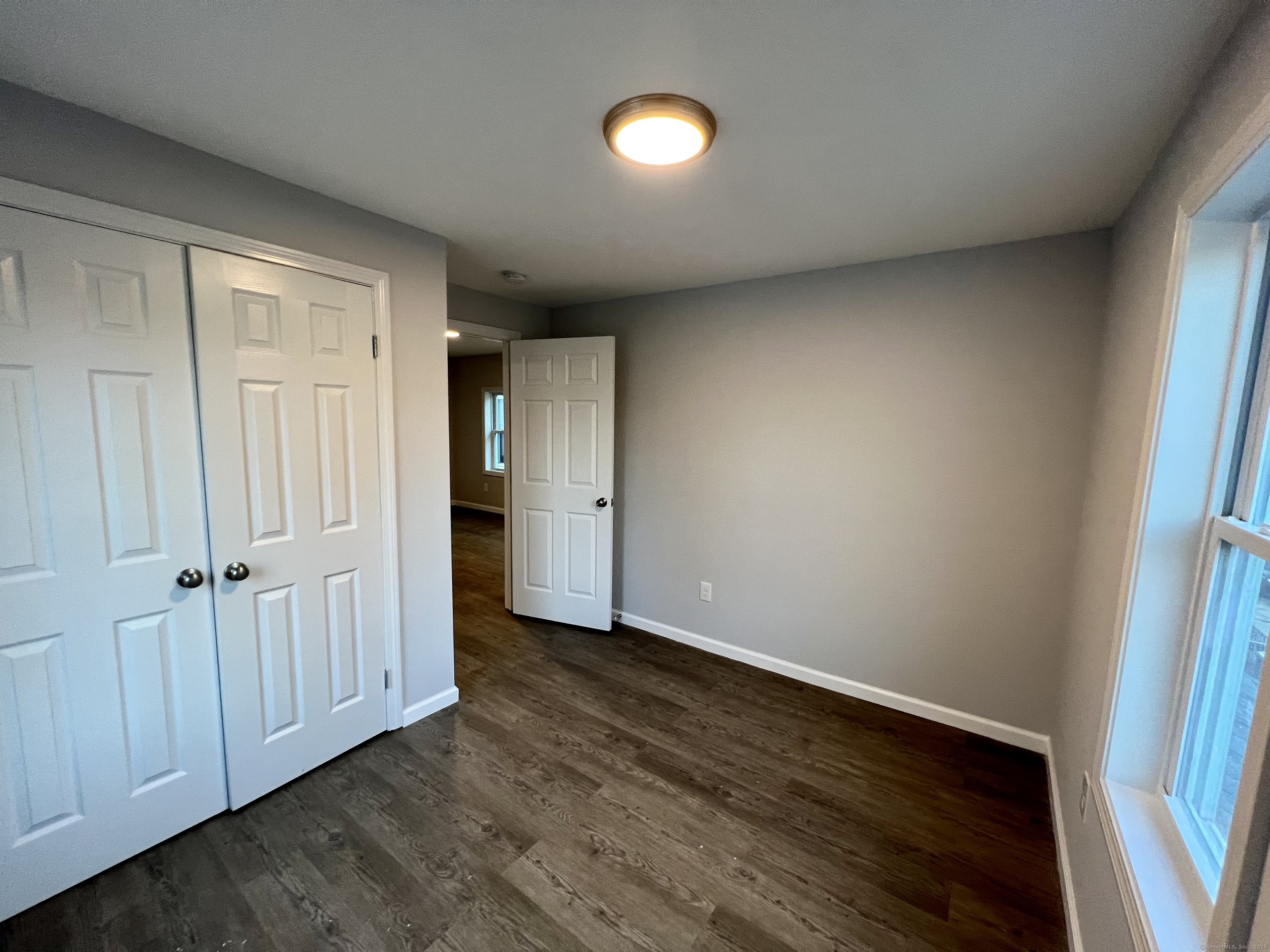 415 Hollister Avenue Bridgeport, CT 06607 - Photo 8 of 14 a view of an empty room with wooden floor