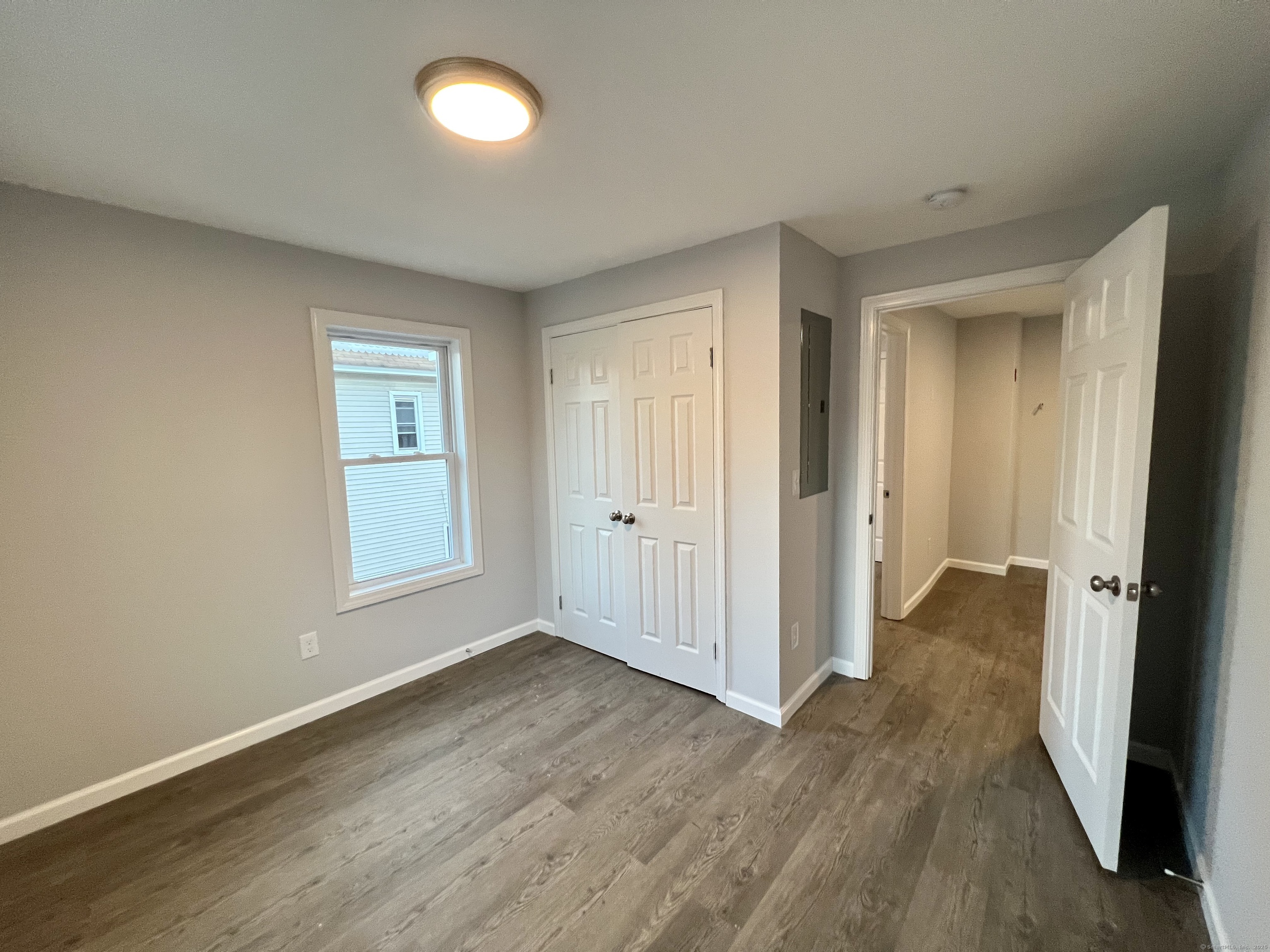 415 Hollister Avenue Bridgeport, CT 06607 - Photo 9 of 14 an empty room with wooden floor and windows