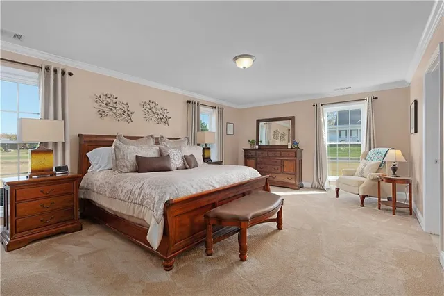 a spacious bedroom with a bed and chair