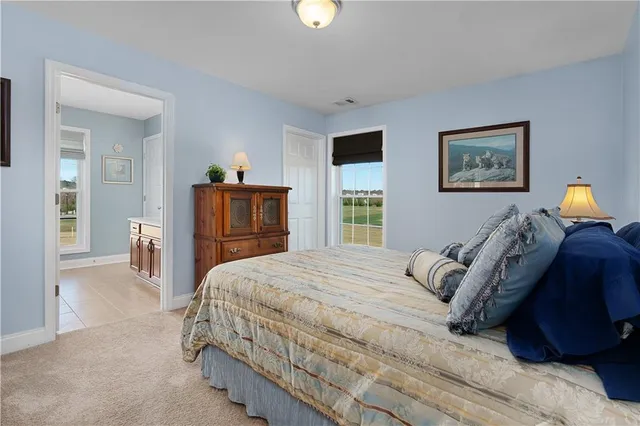 a bedroom with a bed and a lamp on dresser