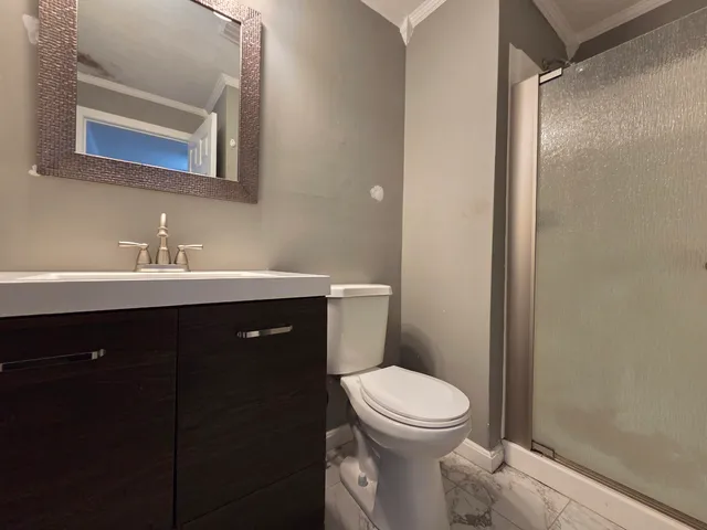 a bathroom with a sink vanity mirror and toilet